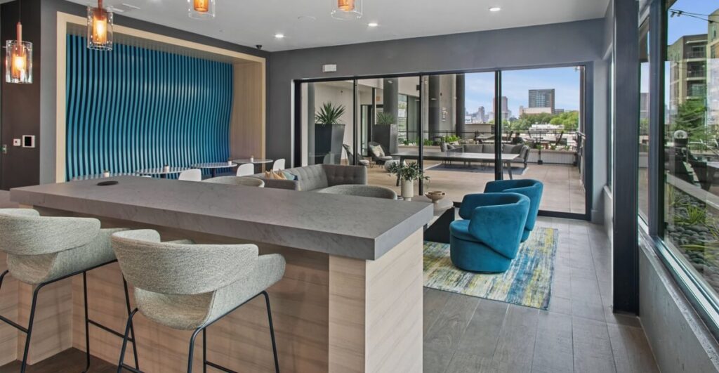 Clubhouse lounge with sofas, TVs, and kitchenette