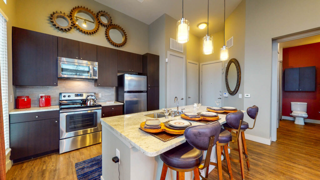 Kitchen with granite counters, stainless steel appliances, and tile backsplash
